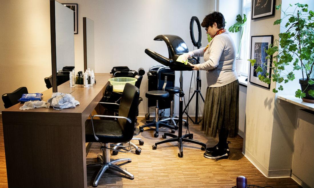 Jette Conradsen, frisør hos Zenz i København, gør rent ved lukning af salonen onsdag den 18. marts. Nu kan hun åbne igen fra på mandag.